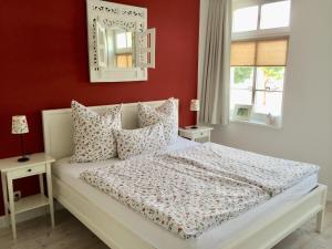 a bedroom with a bed with red walls and a mirror at MÖWE in Ribnitz-Damgarten