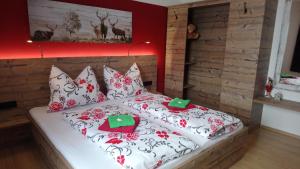 a bedroom with a bed with red and white pillows at Haus Wastl in Russbach am Pass Gschütt