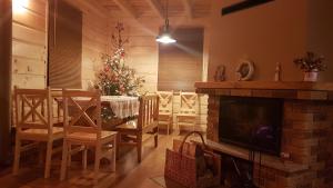 a dining room with a christmas tree and a fireplace at Agroturystyka "Domek pod Praszywką" in Rycerka Górna