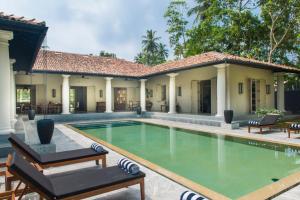 a swimming pool in front of a house at Monara House, Talpe in Unawatuna