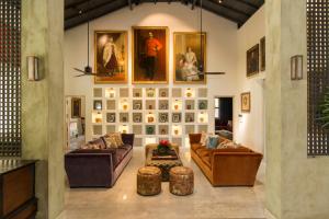 a living room with couches and pictures on the wall at Monara House, Talpe in Unawatuna