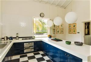 a kitchen with blue cabinets and a checkered floor at Monara House, Talpe in Unawatuna