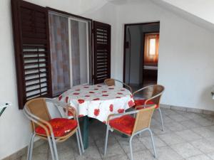 einen Tisch und 4 Stühle in einem Zimmer mit einem Tisch und einem Chairsktop in der Unterkunft Apartmani Dokoza in Drage