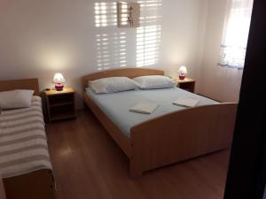 ein Schlafzimmer mit einem großen Bett und zwei Nachttischen in der Unterkunft Apartmani Dokoza in Drage