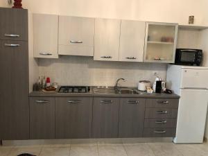 kuchnia z brązowymi szafkami i białą lodówką w obiekcie Casa Comasia w mieście Martina Franca +30 zdjęć