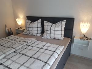 ein Schlafzimmer mit einem Bett mit Kissen und zwei Lampen in der Unterkunft Ferienwohnung Moritz in Sankt Aldegund
