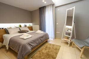 um quarto com uma cama grande e um espelho em M&D Luxury Suites in central Athens em Atenas