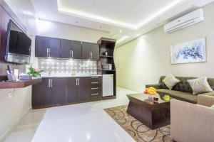 ein Wohnzimmer mit einem Sofa und einer Küche in der Unterkunft Al Muhaidb Residence Al Dawadmi in Ad-Dawādimi