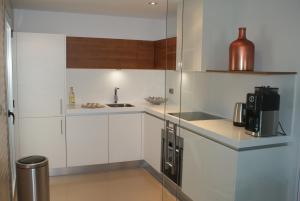 a small kitchen with white cabinets and a sink at Los Arqueros Beach Marbella in Marbella