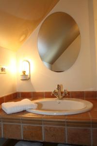 een badkamer met een wastafel met een ronde spiegel bij Kronau Chalet Resort in Kranjska Gora