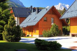 a large wooden house with a roof at Kronau Chalet Resort in Kranjska Gora