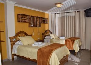 苏克雷Hotel San Felipe的一间黄色墙壁的房间里有两张床