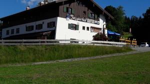 a large white building on a hill with a grass field at Gasthof Seeweg in Oberstdorf