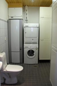 a kitchen with a refrigerator and a washing machine at Kotareitti Apartments in Rovaniemi