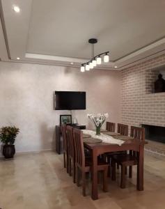 a dining room with a table and chairs and a television at Nouaceur Garden Comfort and Serenity Casa Airport in Nouaseur