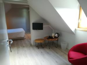 um quarto com uma cama, uma mesa e uma cadeira em Aux Caprices d'Aubrac em Laguiole