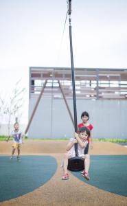 two children sitting on a swing at a playground at BSP21 in Jenjarum