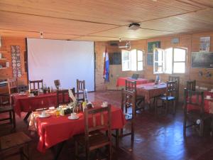 un comedor con mesas y sillas y una pantalla de proyección en Observatorio Ampimpa in 