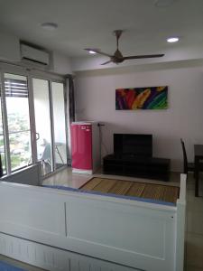 a living room with a red refrigerator and a tv at D'Perdana Apartment 2 in Kota Bharu