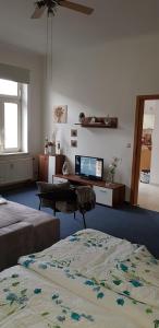 Habitación con 2 camas, escritorio y TV. en FeWo im Herzen Reichenbachs, en Reichenbach im Vogtland