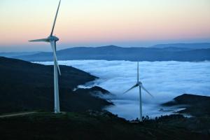 dois moinhos de vento numa colina acima de um mar de nuvens em Miradouro da Branda em Branda de Santo António