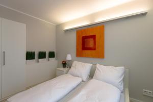 ein weißes Zimmer mit weißen Kissen auf einem Bett in der Unterkunft Wohnung für 4 Pers in Sechtem bei Köln/Bonn, DB-Anschluß in Bornheim