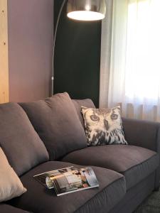 a living room with a gray couch with a magazine on it at Gastenverblijf De Lorem in Leusden