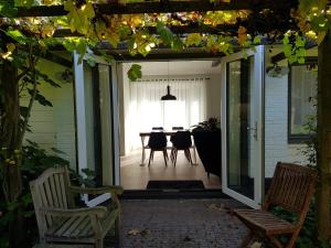 an open door to a patio with chairs and a table at Gastenverblijf De Lorem in Leusden