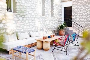 un patio con sofá, 2 sillas y una mesa en La Maison des Ailleurs, en Essaouira