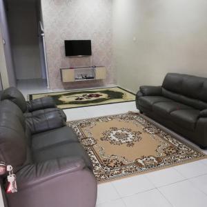ein Wohnzimmer mit einem Sofa und einem Teppich in der Unterkunft Hazim Homestay Changlun Pakej Esklusif in Changlun