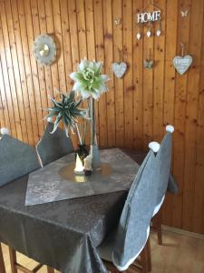 a table with chairs and a vase with flowers on it at Ferienwohnung Renate in Arnoldstein