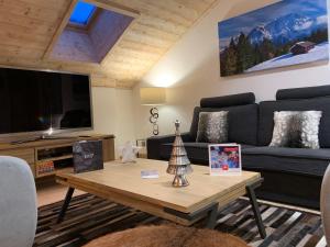 ein Wohnzimmer mit Sofa und Tisch in der Unterkunft Arc 1950 - derniére étage in Arc 1950