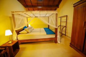 a bedroom with a bed with a canopy at Lenora Villas in Bentota