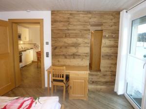 Habitación con pared de madera y mesa de madera. en Ferienhof "Alpe Berg", en Balderschwang