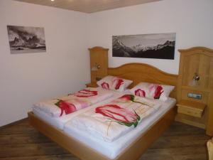 a bedroom with two beds with red pillows on them at Ferienhof "Alpe Berg" in Balderschwang