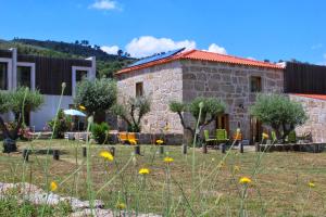 a stone house with a garden in front of it at Quinta Vale da Prata in Celorico da Beira