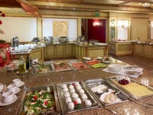 クリニツァ・ズドルイにあるHotel Mercure Krynica Zdrój Resort&Spaの広いキッチン(食べ物がたっぷりと並ぶテーブル付)