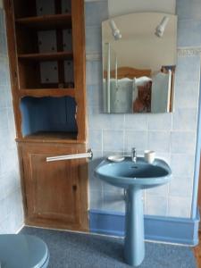ein Bad mit einem Waschbecken und einem Spiegel in der Unterkunft Gîte "Cadichon" in Munster
