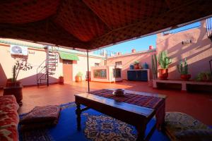 een woonkamer met een tafel in het midden bij Riad Dar Rita in Ouarzazate