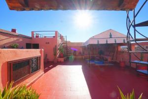 a patio of a house with the sun in the sky at Riad Dar Rita in Ouarzazate