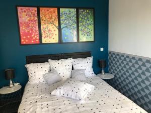 een slaapkamer met een bed met drie schilderijen aan de muur bij Chez Frédérique et Jean-Claude in Les Taillades