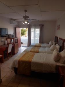 a bedroom with two beds and a kitchen and a table at hotel pension steiner in Windhoek