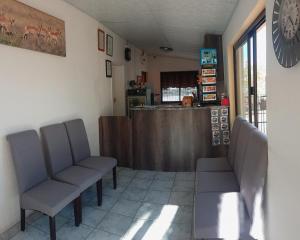 una sala d'attesa con due sedie e un bancone di hotel pension steiner a Windhoek