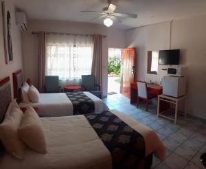 Habitación de hotel con 2 camas y sala de estar. en hotel pension steiner, en Windhoek
