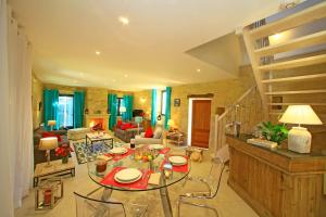 een woonkamer met een tafel en stoelen en een trap bij La Malonie in Sarlat-la-Canéda