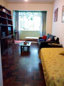 a living room with a bed and a couch and a table at Copacabana apartment with a living room and 2 sleeping rooms in Rio de Janeiro