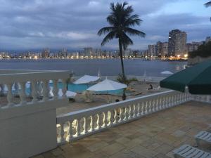 a balcony with a view of the water and a city at Ilha Porchat Hotel in São Vicente