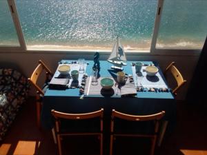 a table with a blue table cloth and a sailboat on it at Casa do Espadarte in Sesimbra