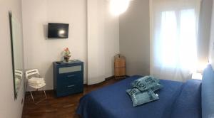 ナポリにあるcasa via dei fiorentiniのベッドルーム1室(青いベッド1台、青いドレッサー付)