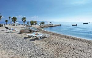 a beach with chairs and tables on a rocky beach at Apartman Marta in Podstrana